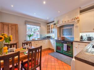 a kitchen with a table and a green oven at Pass the Keys Cosy 2 Bed Cottage With Views of The Iron Bridge in Ironbridge