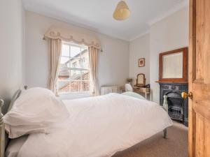 a white bedroom with a bed and a window at Pass the Keys Cosy 2 Bed Cottage With Views of The Iron Bridge in Ironbridge