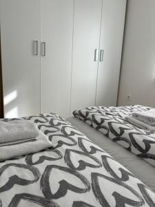 two beds in a room with white cabinets at Apartments Heart in Ljubljana