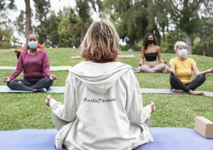 um grupo de pessoas sentadas em um parque fazendo yoga em RusticParaiso: Family, Team & Group Urban Retreat em Greensboro