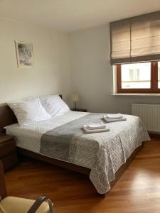 a bedroom with a bed with two towels on it at Szucha Residence Apartments by Global Apart in Warsaw