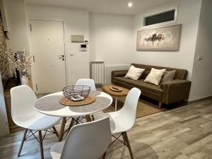 ein Wohnzimmer mit einem Tisch, Stühlen und einem Sofa in der Unterkunft Apartamento Lux Santiago in Santiago de Compostela