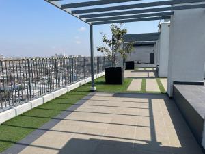 Hermosa y Cómoda Habitación في سانتياغو: شرفة بها عشب أخضر وسياج