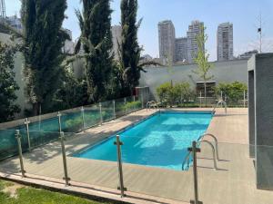 una piscina con una valla alrededor en Hermosa y Cómoda Habitación, en Santiago