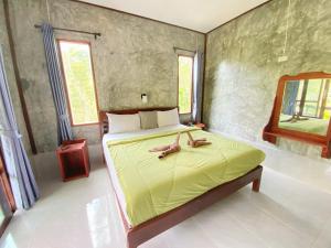 ein Schlafzimmer mit einem Bett mit zwei Handtüchern darauf in der Unterkunft Ban Choengkao in Ko Kood