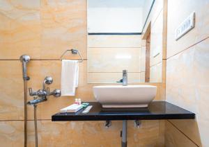 ein Bad mit einem Waschbecken und einem Spiegel in der Unterkunft Hotel Royal Palace in Sāgar