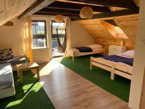 - une chambre avec 2 lits et un tapis vert dans l'établissement Pokoje nad jeziorem z opcją szkolenia żeglarskiego, à Pluski