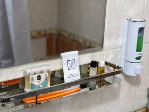 a bathroom with a mirror and a shelf with cosmetics at Welcome TJ Apartment in Khujand