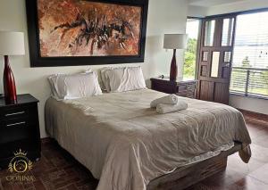 a bedroom with a bed and a painting on the wall at Cabaña tota paraiso con muelle in Cuítiva