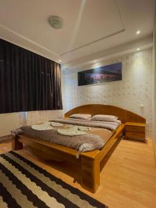1 dormitorio con 1 cama grande de madera en una habitación en Hotel sofra en Ferizaj