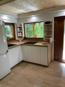 a kitchen with white cabinets and a large window at KENT in Mărişel