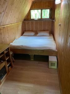 a small bedroom with a bed in a wooden cabin at KENT in Mărişel