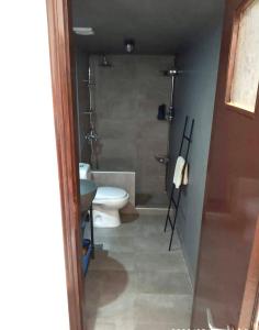 a bathroom with a toilet and a shower and a sink at House of South in Yiannioú