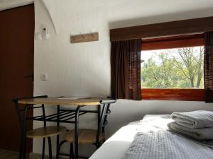 um quarto com uma cama, uma mesa e uma janela em Glamping PEC - All Inclusive light em Selnica ob Dravi