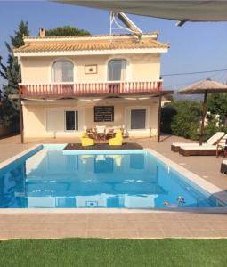 a swimming pool in front of a house at Villa Evenik in Eretria