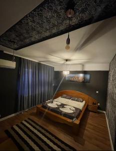 ein Schlafzimmer mit einem Bett mit einem Bettrahmen aus Holz in der Unterkunft Hotel sofra in Ferizaj