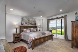 ein Schlafzimmer mit einem Bett und einem großen Fenster in der Unterkunft BRAND NEW! Outstanding Luxury Lakefront Lodge with Free Amenities in Kimberling City + 80 Fotos