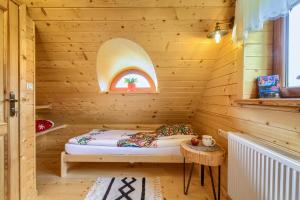 a sauna with a bed in a wooden room at Tylickie Chałupy in Tylicz