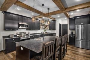 a kitchen with black cabinets and a large island at Serenity Shores Resort - Luxury Lakefront Lodge - Pools and Many Free Amenities in Kimberling City