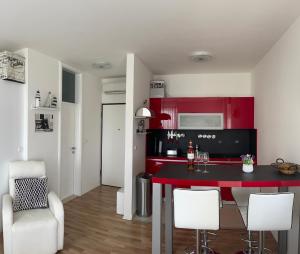 a kitchen with red cabinets and a table and chairs at Studio Apartment Pag Luxury 4U in Pag