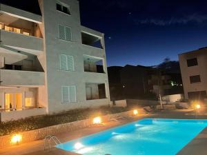 a swimming pool in front of a building at night at Studio Apartment Pag Luxury 4U in Pag
