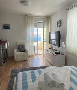 a bedroom with a bed and a television and a living room at Studio Apartment Pag Luxury 4U in Pag