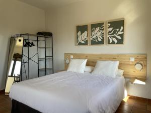 1 dormitorio con 1 cama blanca grande y 2 almohadas en Apartamentos Los Pocillos, en Gargantilla del Lozoya