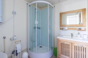 a bathroom with a glass shower and a sink at Maisonnette dans jardin partagé in Colombes +12 photos