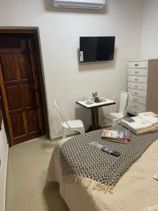 a bedroom with a bed and a table and a tv at Pucara Apart - Habitaciones con baño privado in Corrientes
