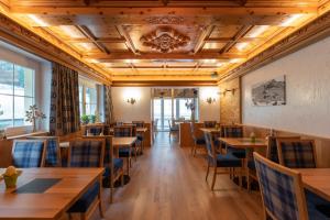 a dining room with wooden tables and chairs at Alpenhotel Erika in Ischgl