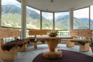 イシュグルにあるAlpenhotel Erikaのテーブル、ベンチ、山々が備わる広い客室です。