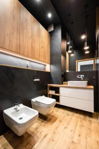 a bathroom with a white sink and a toilet and a sink at Metro Imielin 13th Floor Apartment by BookingHost in Warsaw +15 photos