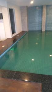 a swimming pool with green water in a building at Cabo Frio - Temporadas in Cabo Frio