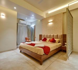 een slaapkamer met een groot bed met rode kussens bij Hotel Swamini Kolhapur in Kolhapur