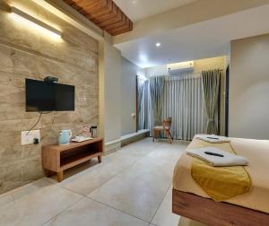 een hotelkamer met een bed en een flatscreen-tv bij Hotel Swamini Kolhapur in Kolhapur