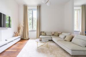 ein weißes Wohnzimmer mit einem Sofa und einem Tisch in der Unterkunft San Marco White Appartamento Luxury con Garage su richiesta in Florenz