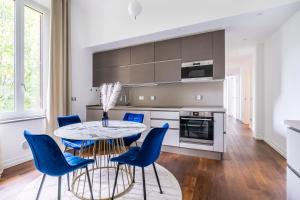 eine Küche mit einem Tisch und blauen Stühlen in der Unterkunft San Marco White Appartamento Luxury con Garage su richiesta in Florenz