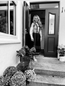 una mujer parada en la puerta de una casa en Villa Henrikke Myhre, en Osøyro