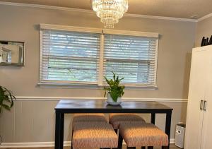a dining room with a table and stools and a window at RusticParaiso: Family, Team & Group Urban Retreat in Greensboro