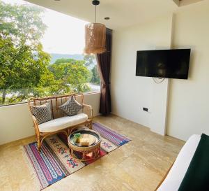 a living room with a chair and a large window at Baan Khao Hua Jook in Chaweng