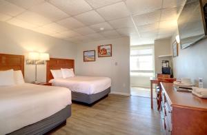 a hotel room with two beds and a kitchen at Atlantic Oceanfront Hotel, Wells Beach in Wells