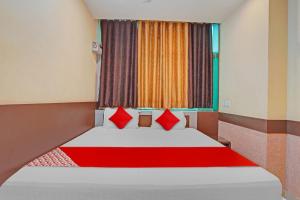 a bedroom with a bed with red pillows and a window at Flagship The Leggend Inn Hotel in Patna