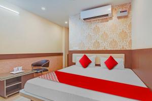 a bedroom with a bed with red pillows and a desk at Flagship The Leggend Inn Hotel in Patna