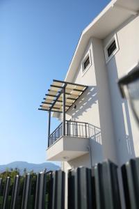 een wit huis met een balkon en een hek bij Bright House Apart in Ortaca