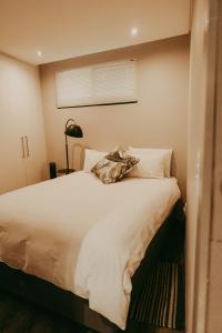 a bedroom with a white bed with a pillow on it at VELDT Suite - Luxury Apartment near Grove Mall & Hospital Airbnb in Windhoek