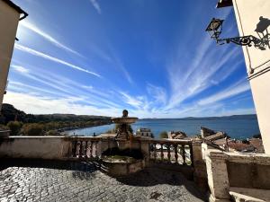 a man standing on a bridge overlooking the water at Dolce vita al lago in Anguillara Sabazia
