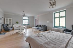 a white living room with a bed and a dining room at Historical Townhouse by Blue Mandarin in Gdańsk