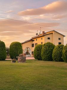 ein Gebäude auf einem Feld mit Büschen davor in der Unterkunft Agriturismo Ca' Del Sol in Lazise