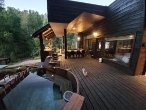 a house with a swimming pool on a wooden deck at Casa Pucon sector Laguna ancapulli in Pucón