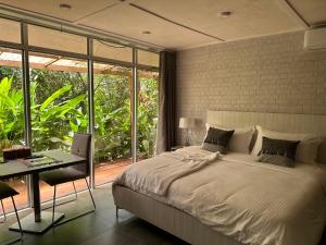 a bedroom with a bed and a desk and a window at Tropicana Beach & Resort in Elwa